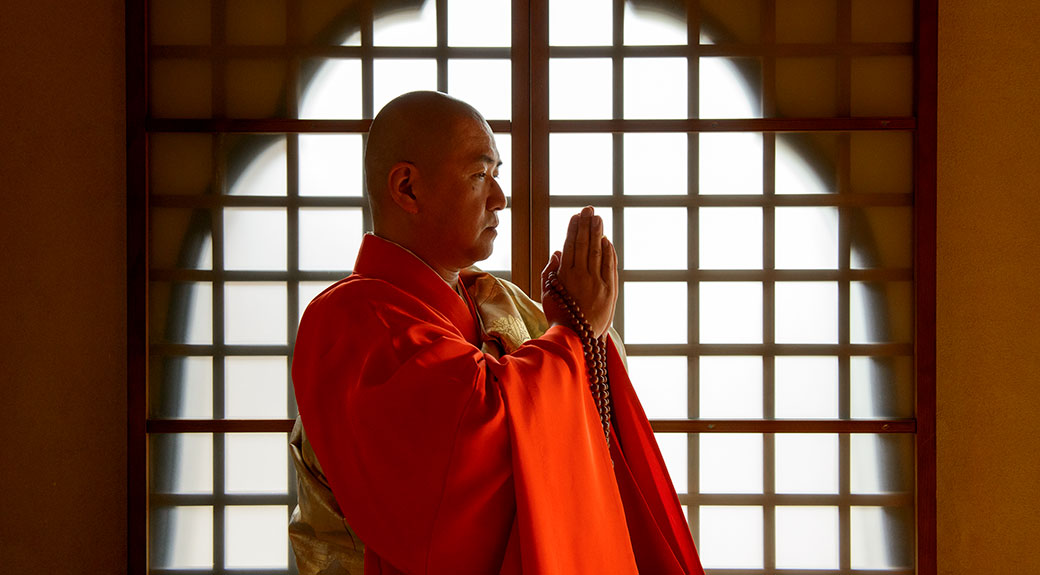 曹洞宗大泉寺住職久保井賢丈師の合掌する姿と伝統的な袈裟姿での読経風景